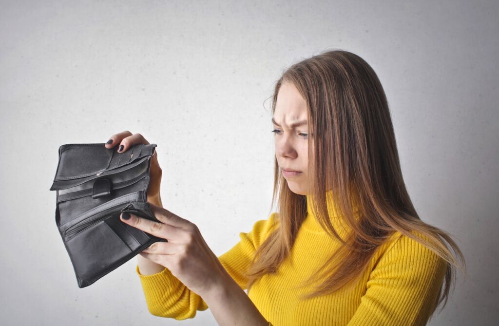 A woman examining an empty wallet.